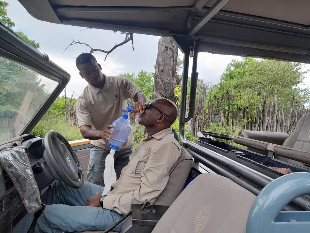 Trainee practising bag-valve-mask airway ventilation on a casualty inside a safari game viewer during Cardio Life first aid training in Botswana