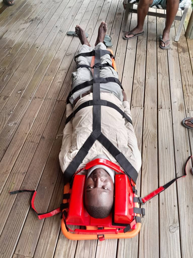 Casualty fully immobilised on a spineboard with head blocks and straps during Cardio Life spinal care training